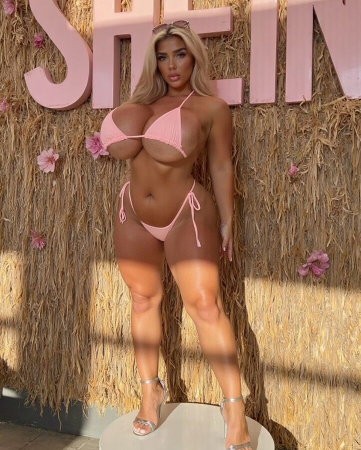 Plastic fake bimbo blonde exposing curvy body and massive boobs in bikini
